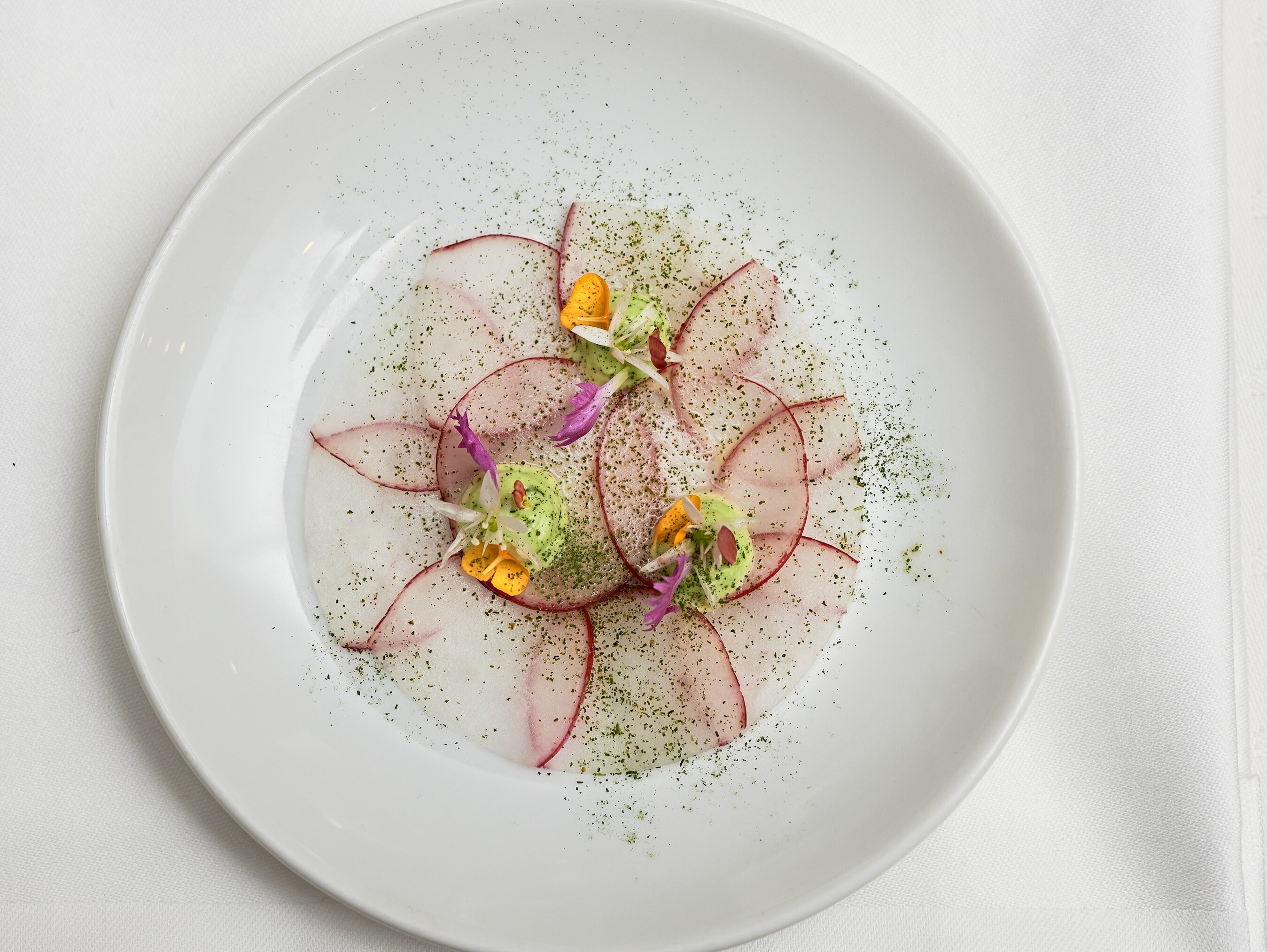 Ein Teller mit Essen auf einem Tisch, umgeben von Besteck.