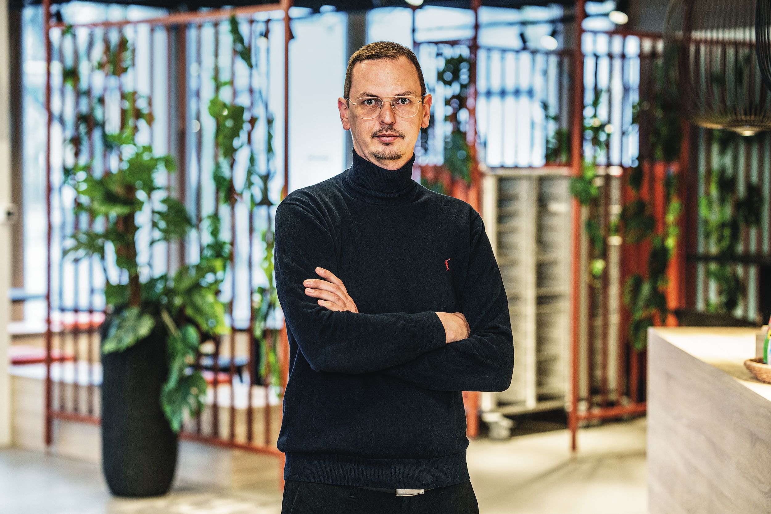 Alexander Thiel, Leiter Verpflegungsdienste Ein Mann mit Brille und Rollkragenpullover lächelt.
