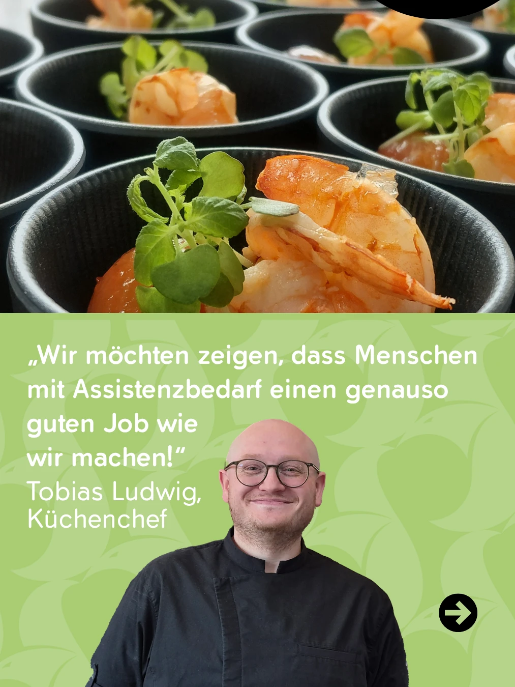 Küchenchef Tobias Ludwig mag seinen Job. Ein Mann lächelt in einem schwarzen Hemd.