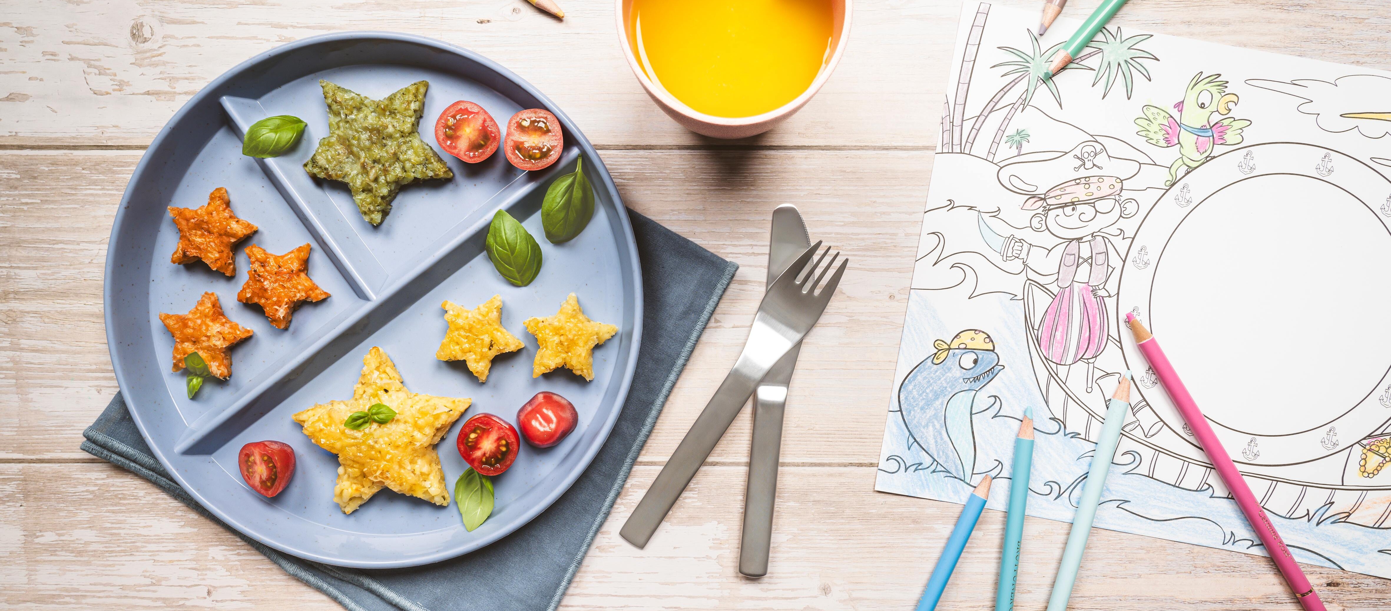 Bunte Risottosterne Ein Teller mit Essen, einem Getränk und Bleistiften.