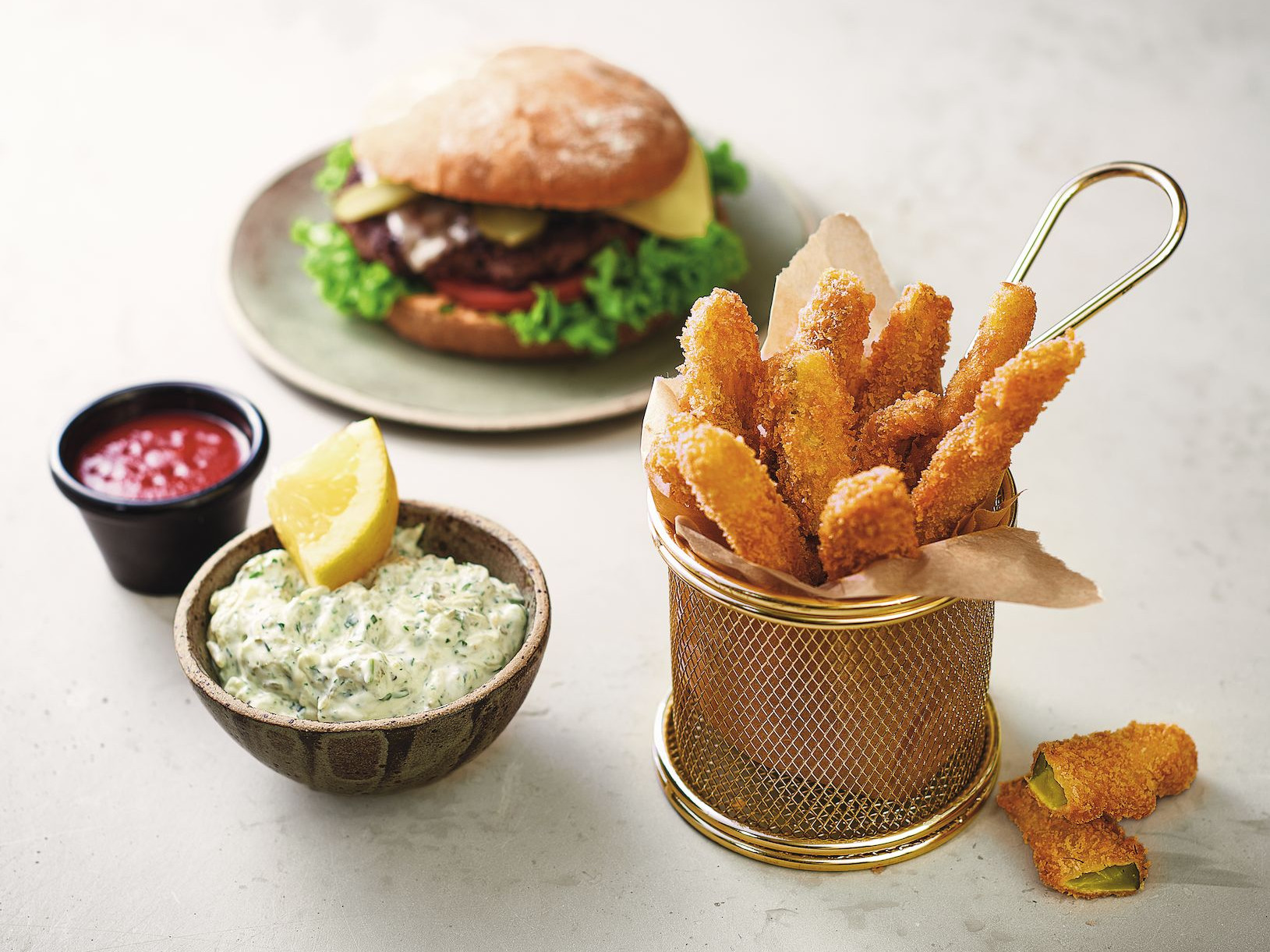 Fried Pickles - frittierte Gewürzgurken Ein Teller mit einem Burger und Sauce.