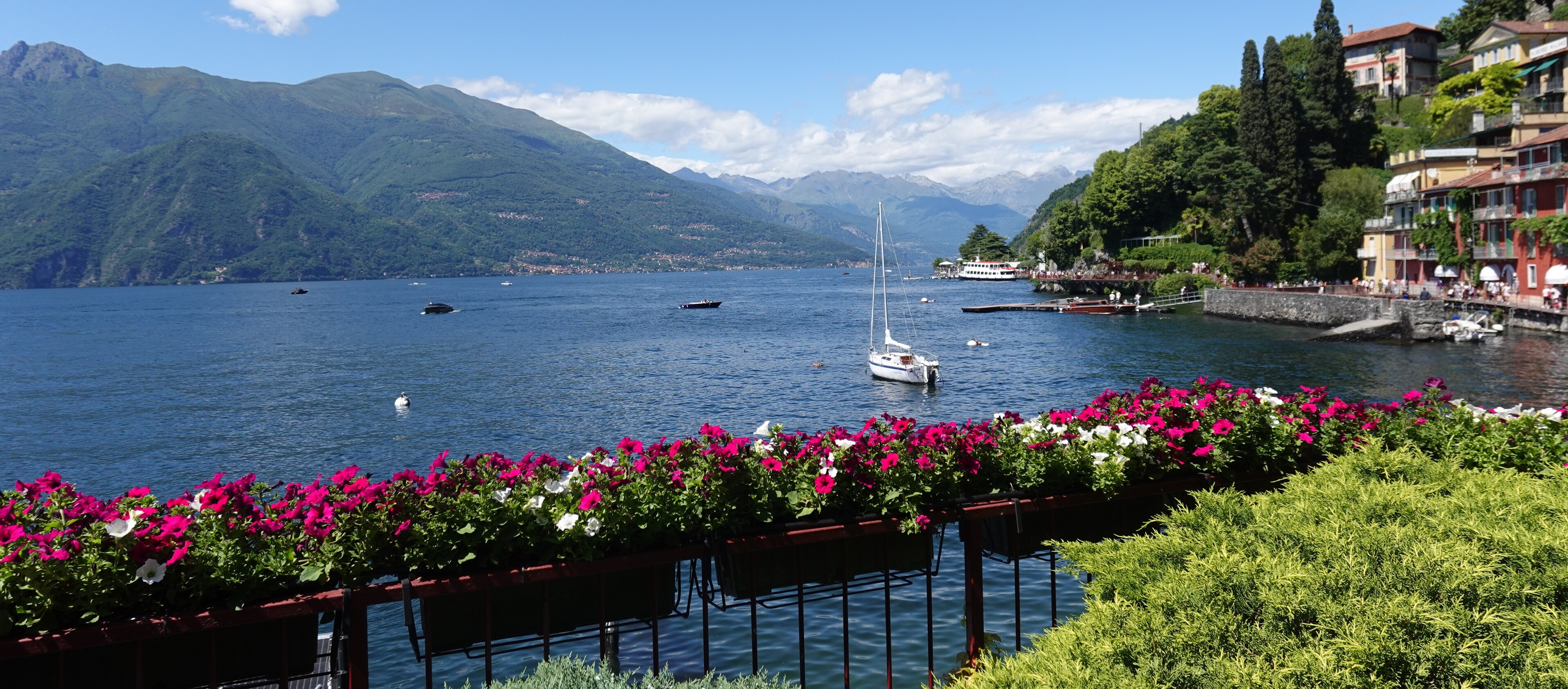 Pasta kochen in Italien Ein See mit Blumen und Bergen im Hintergrund