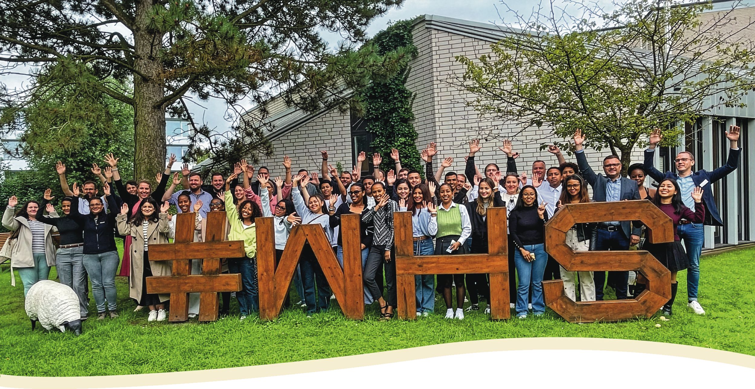 Eine Gruppe von Menschen, die Holzbuchstaben hochhalten.