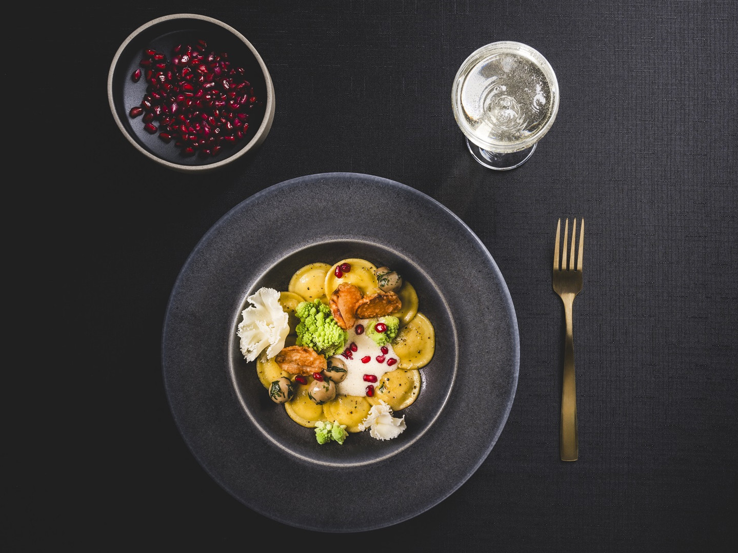 Festliche gefüllte Salva D'Or Lunette mit Champignons, Topinambur, Romanesco und Tête de Moine auf Champagnerschaum Gefüllte Pasta mit Romanesco, Champignons, Topinambur, dazu Granatapfelkerne