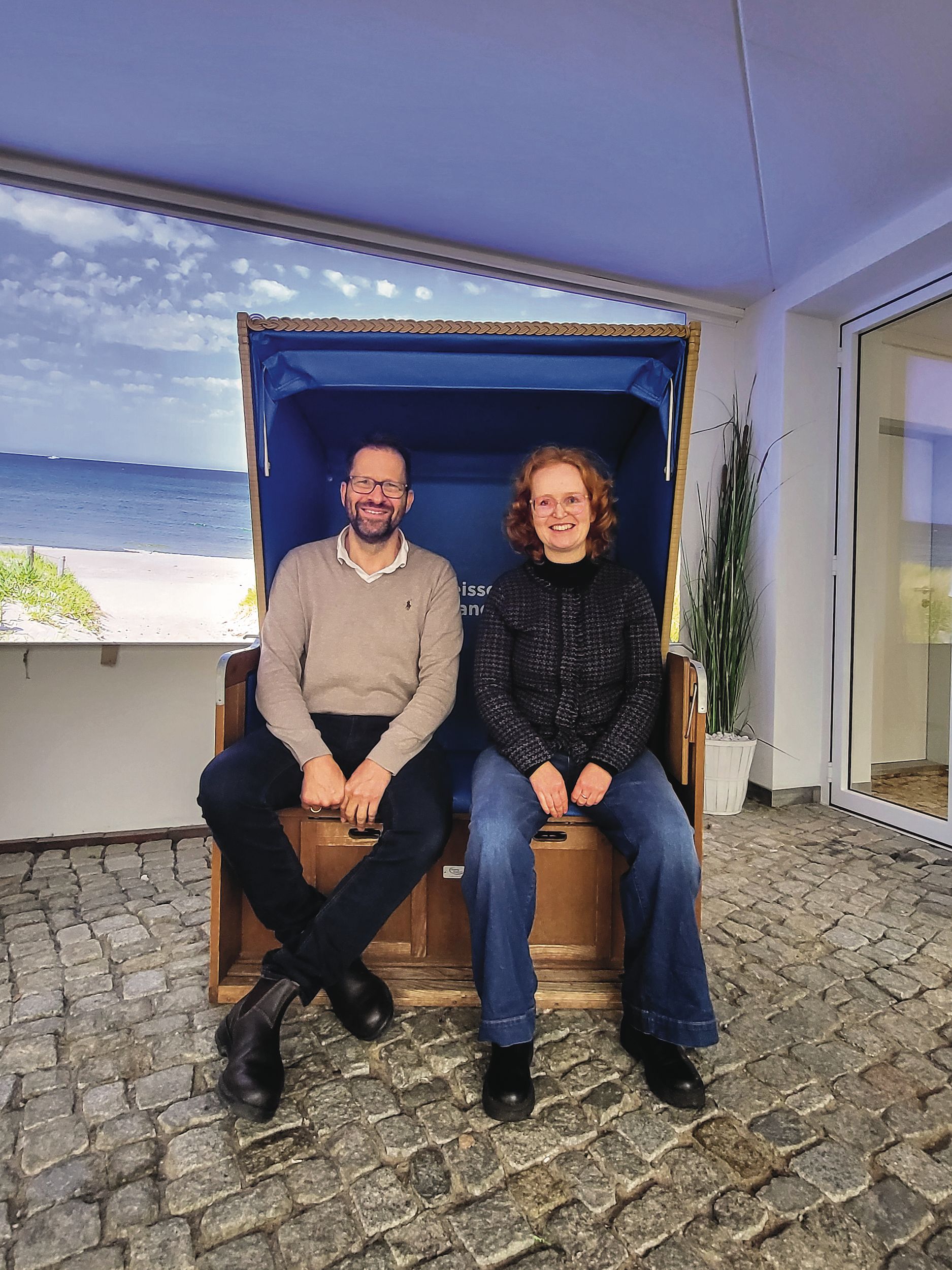 Ein Mann und eine Frau sitzen auf einem Stuhl.