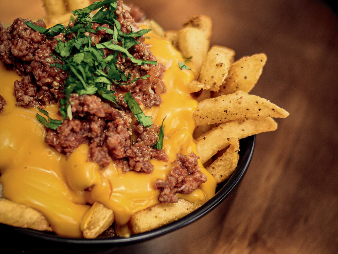 Die ServisaPrime Pommes frites wurden speziell für die Anforderungen der professionellen Gastronomie entwickelt und überzeugen durch gleichbleibend hohe Qualität sowie vielseitige Einsatzmöglichkeiten. Schüssel mit Essen, bestehend aus Käse und Fleisch