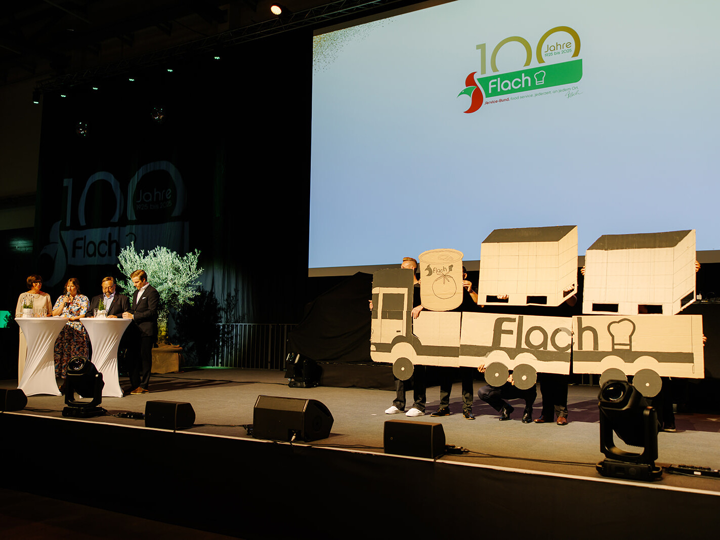Die Familie Flach präsentierte gemeinsam mit Mitarbeitenden die Unternehmensgeschichte – von den ersten Tagen im kleinen Ort Niedergrenzebach bis zur modernen, innovativen Unternehmensstruktur von heute. Die Familie Flach präsentierte gemeinsam mit Mitarbeitenden die Unternehmensgeschichte – von den ersten Tagen im kleinen Ort Niedergrenzebach bis zur modernen, innovativen Unternehmensstruktur von heute.