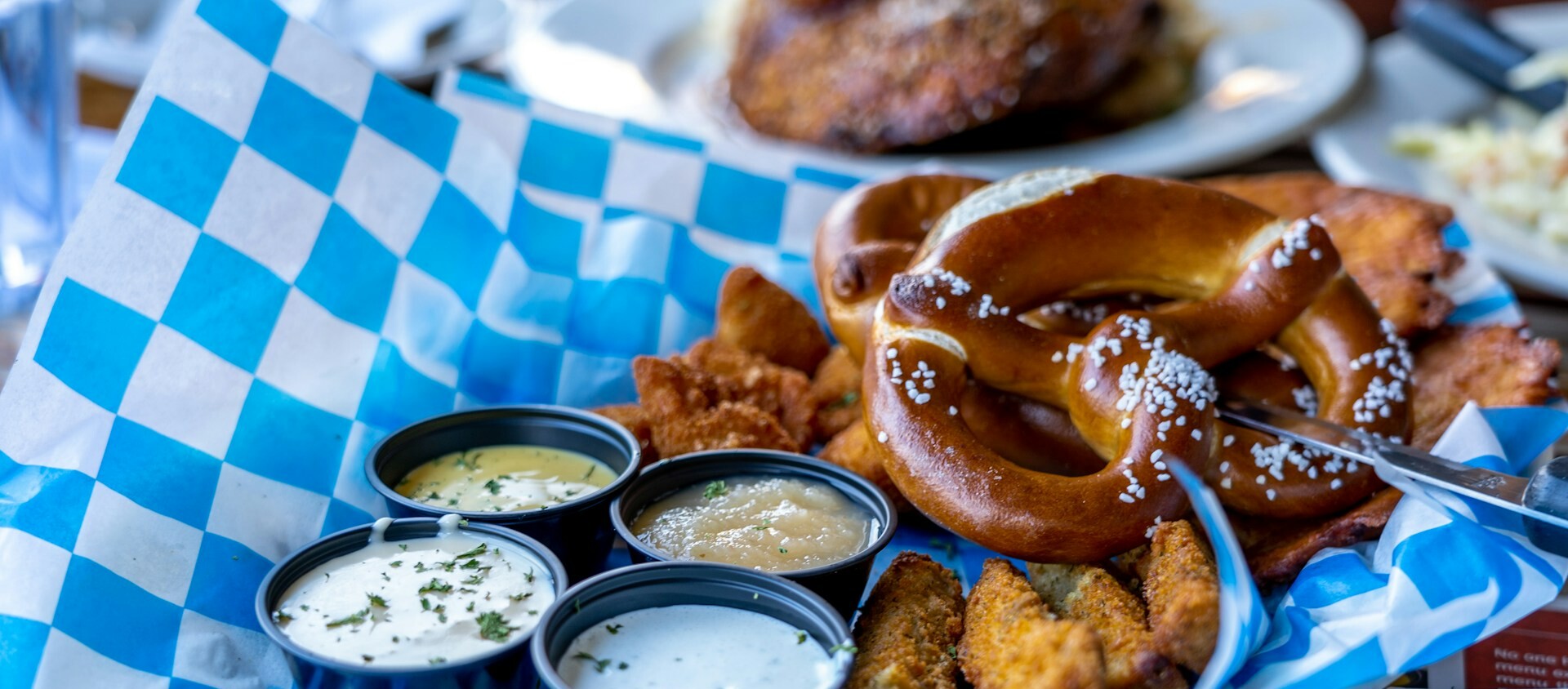 Brezel Ein Teller mit Essen, Saucen und Brezeln.
