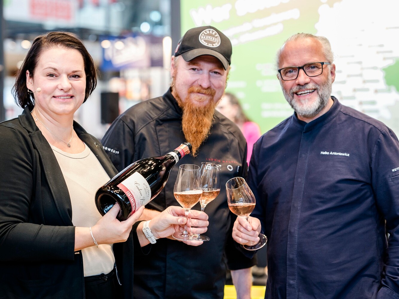Maja Kirsch, Lucki Maurer und Heiko Antoniewicz Drei Personen mit einer Flasche Wein und gefüllten Gläsern