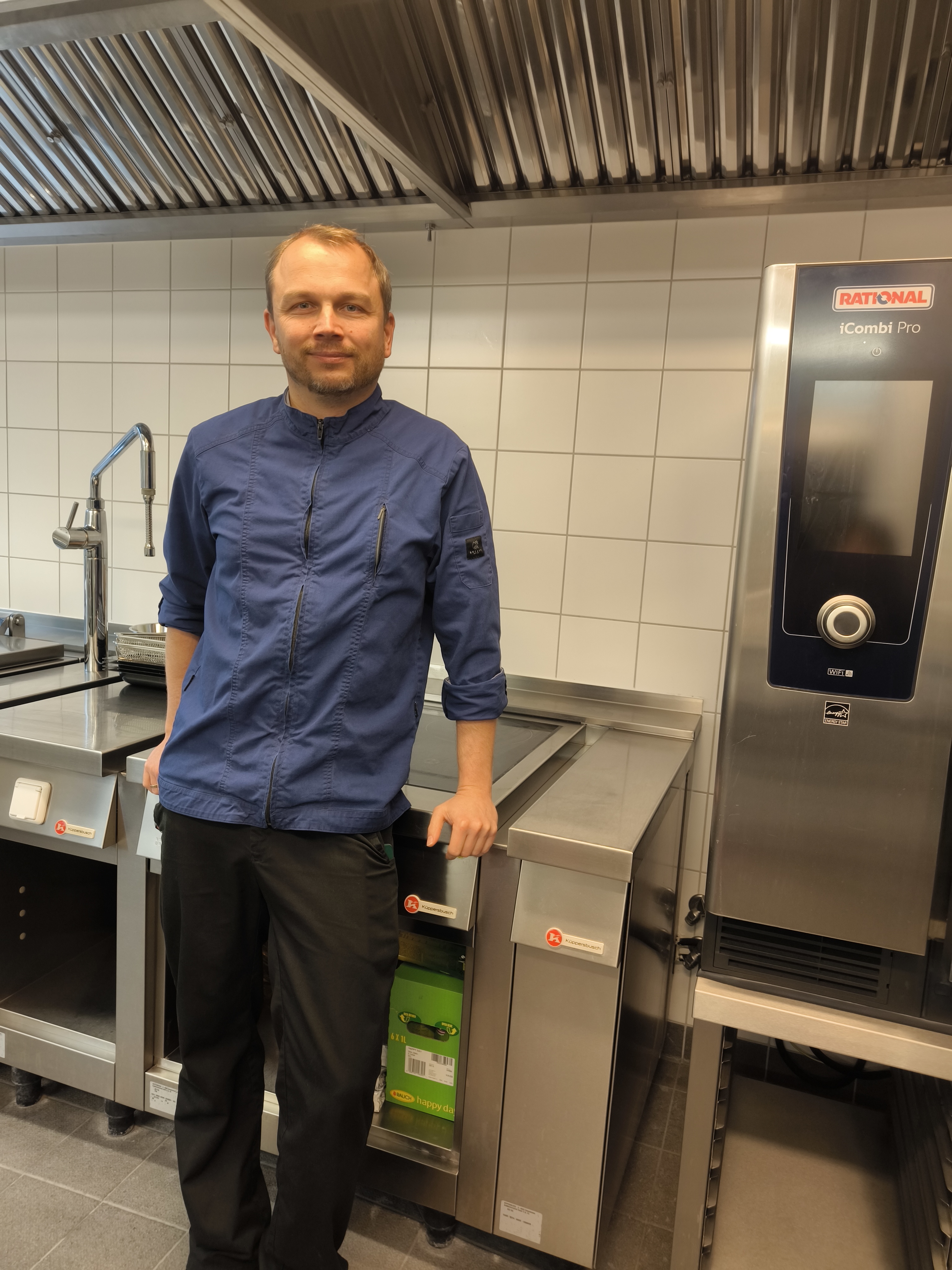 David Top, Küchenchef in der Berliner Kita "Kleine Traber" Ein Mann steht in einer Küche.