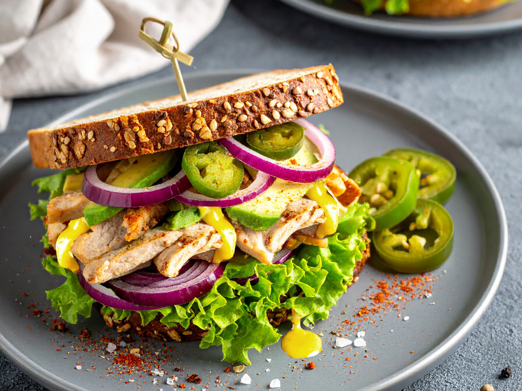 Ein Teller mit einem Sandwich mit Hähnchen und Salat