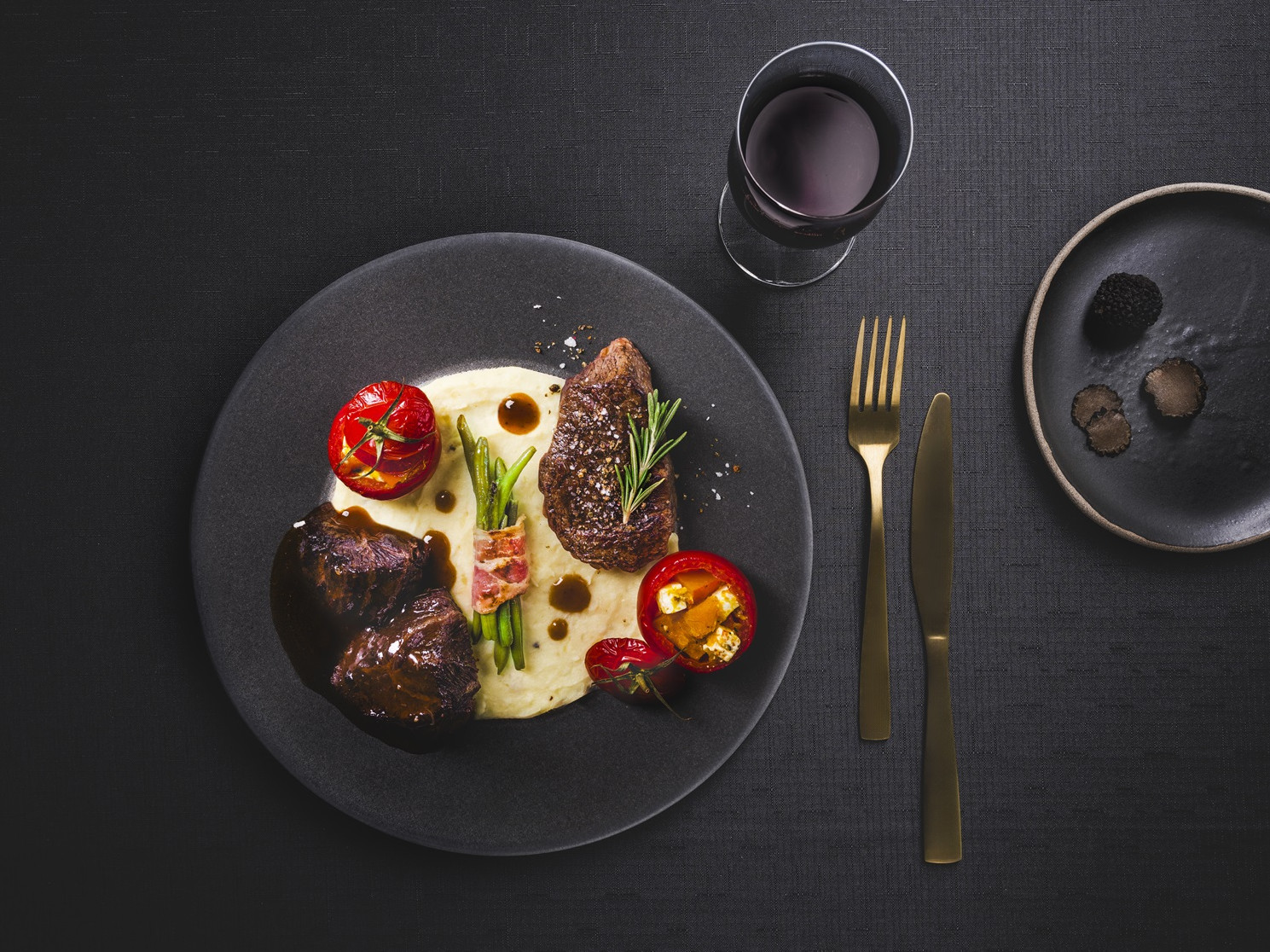 Zweierlei vom Ochsen mit Speckbohnen, Grilltomaten und getrüffeltem Kartoffel-Selleriepüree Ochsenbäckchen und Rinderfilet auf Püree mit gefüllten Tomaten