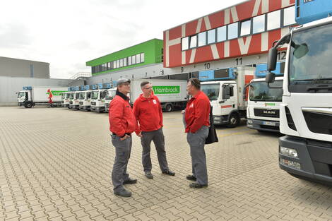 KOllegen stehen auf dem Parkplatz