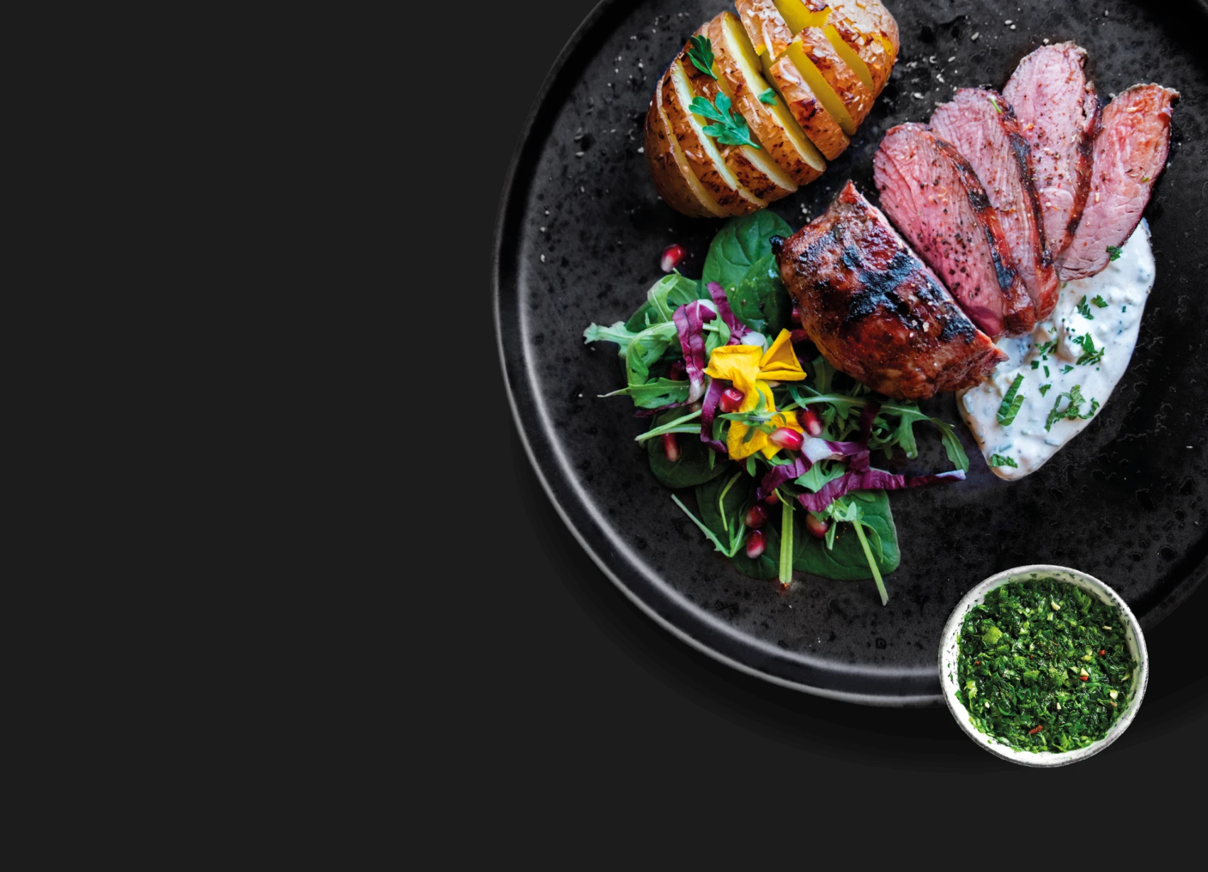 Ein Teller mit Fleisch und Gemüse auf schwarzem Untergrund.