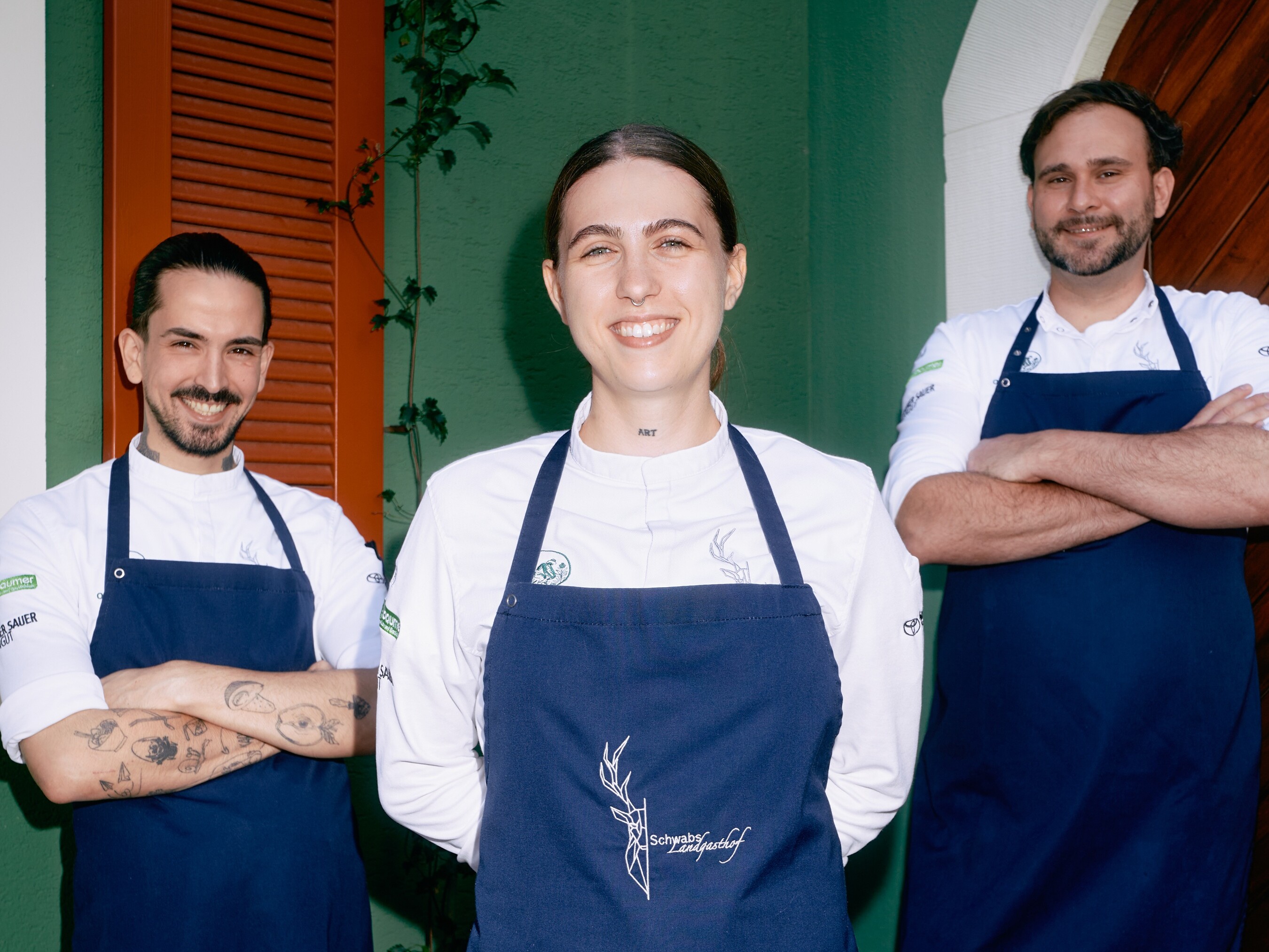 Eine Gruppe von Menschen in Schürzen lächelt.