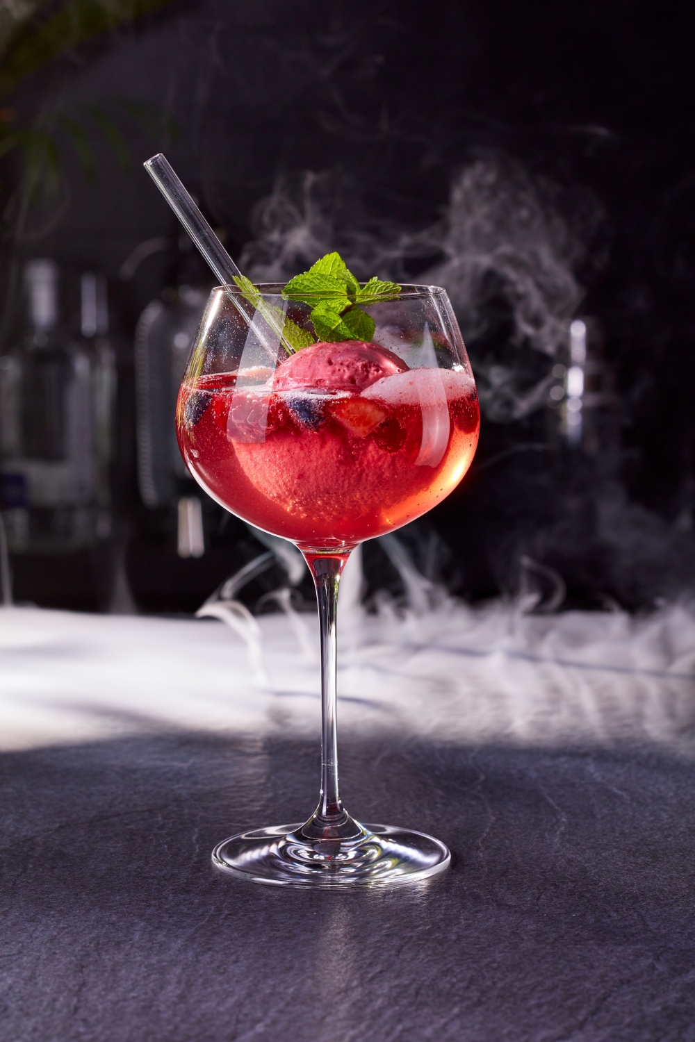 Better Desserts Berry Spritz Ein Glas mit einem Cocktail und einem Strohhalm.