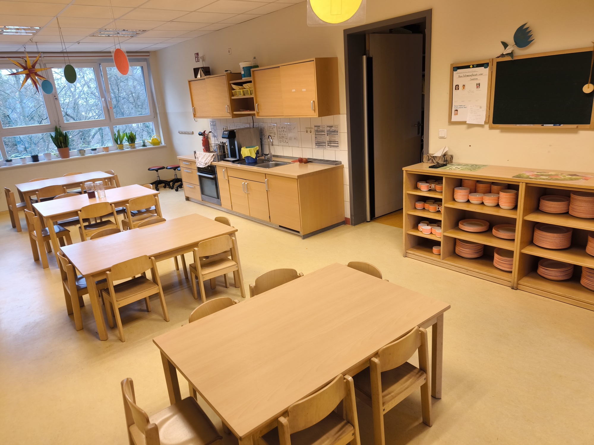 Hier essen die Kita-Kinder. Ein Klassenzimmer mit Tischen und Stühlen.