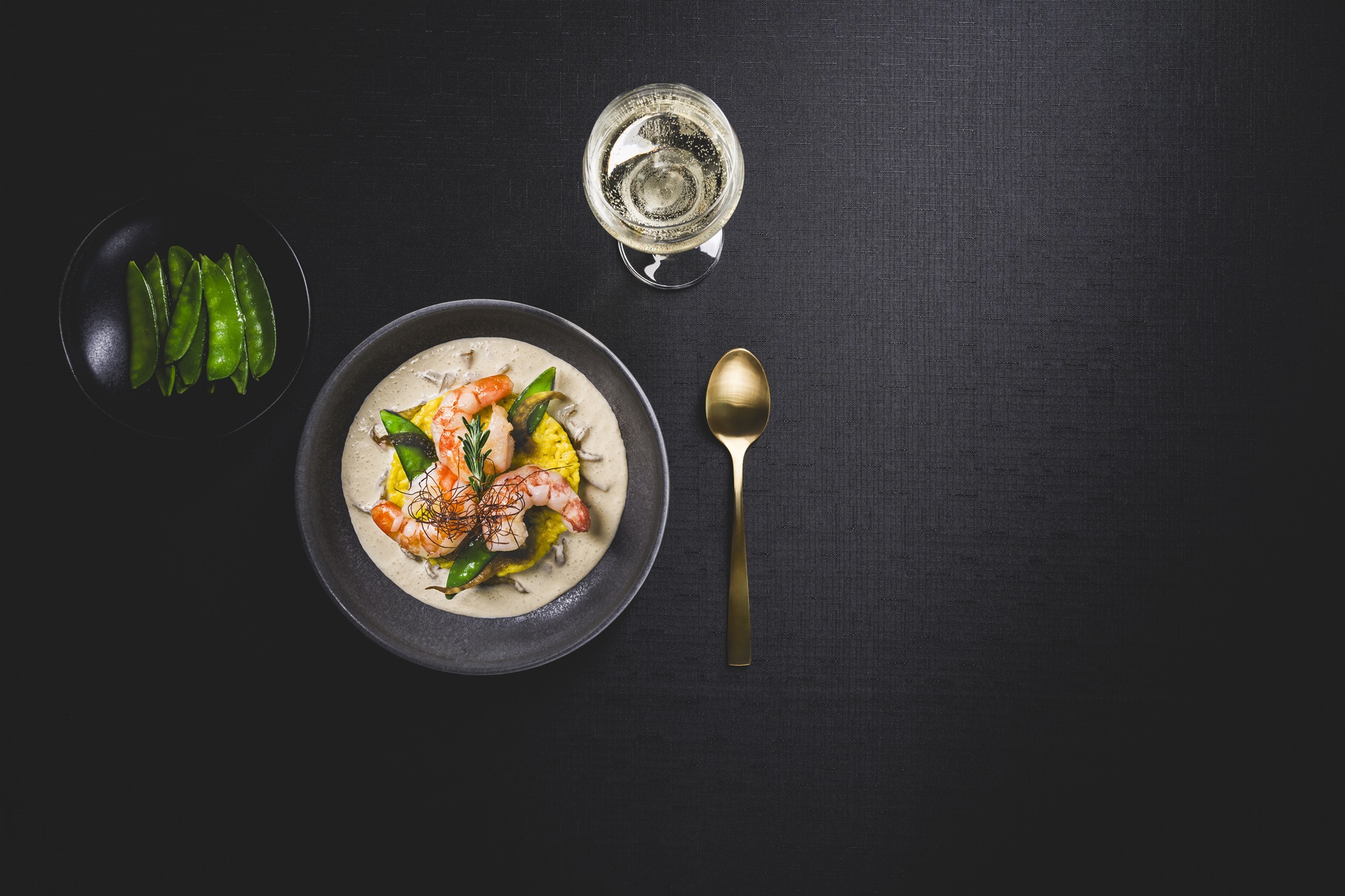 Eine Schüssel mit Essen neben einem Glas Wein.