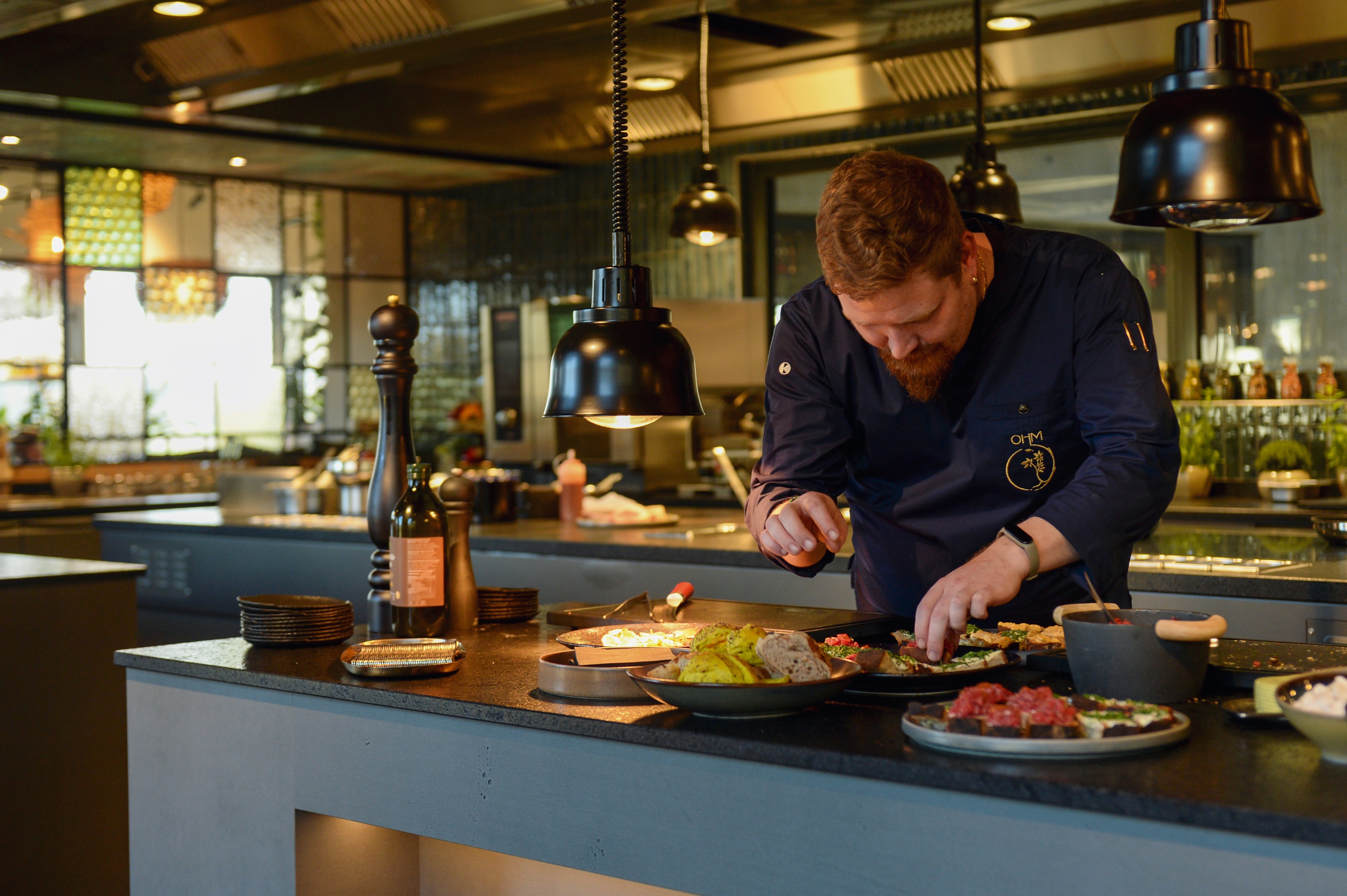 Kulinarik im Gourmetrestaurant OHM Ein Mann kocht Essen in einem Restaurant.