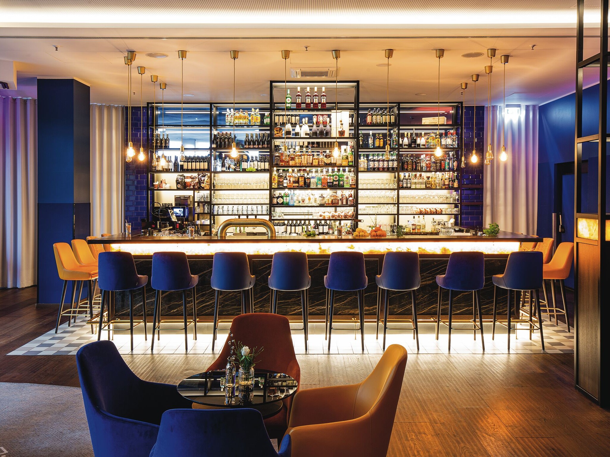 Die MOA Bar Eine Bar mit einer Reihe von Stühlen und einem Tisch.