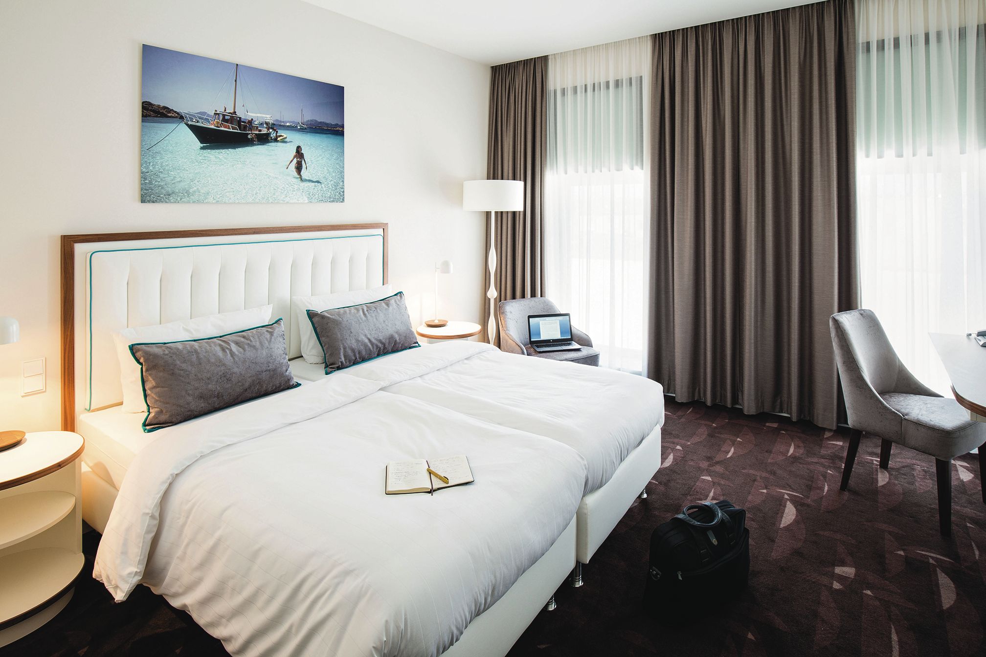 Hotelzimmer im MOA Berlin Hotelzimmer mit zwei Betten und einem Laptop