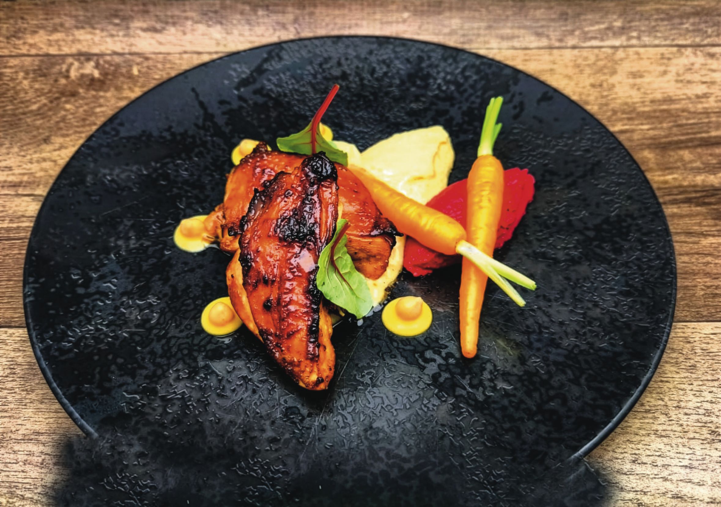 So lecker und gesund kann Kantine sein Ein Teller mit Fleischgericht auf einem Holztisch.