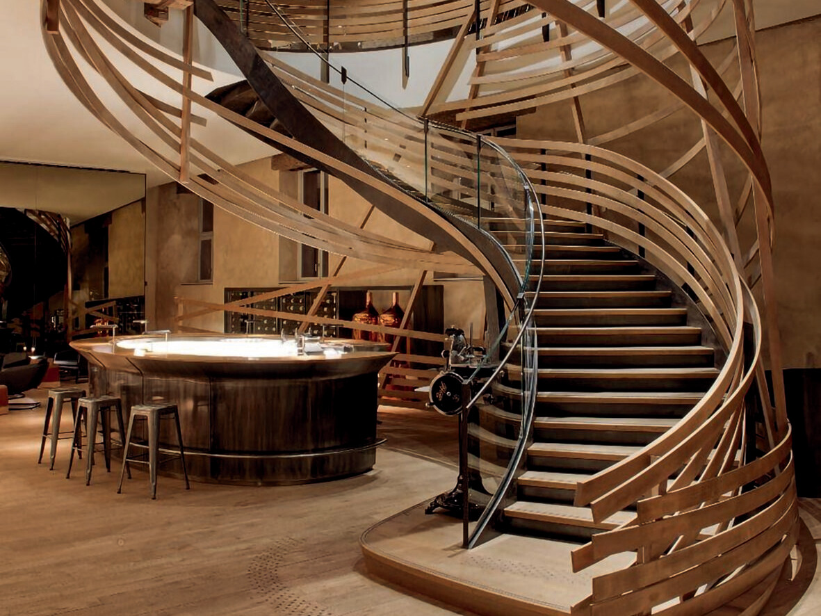 Die spiralförmige Holztreppe im Herzen der Brasserie: ein architektonisches Meisterwerk, das die Vergangenheit mit der Gegenwart verbindet. Die spiralförmige Holztreppe im Herzen der Brasserie: ein architektonisches Meisterwerk, das die Vergangenheit mit der Gegenwart verbindet.