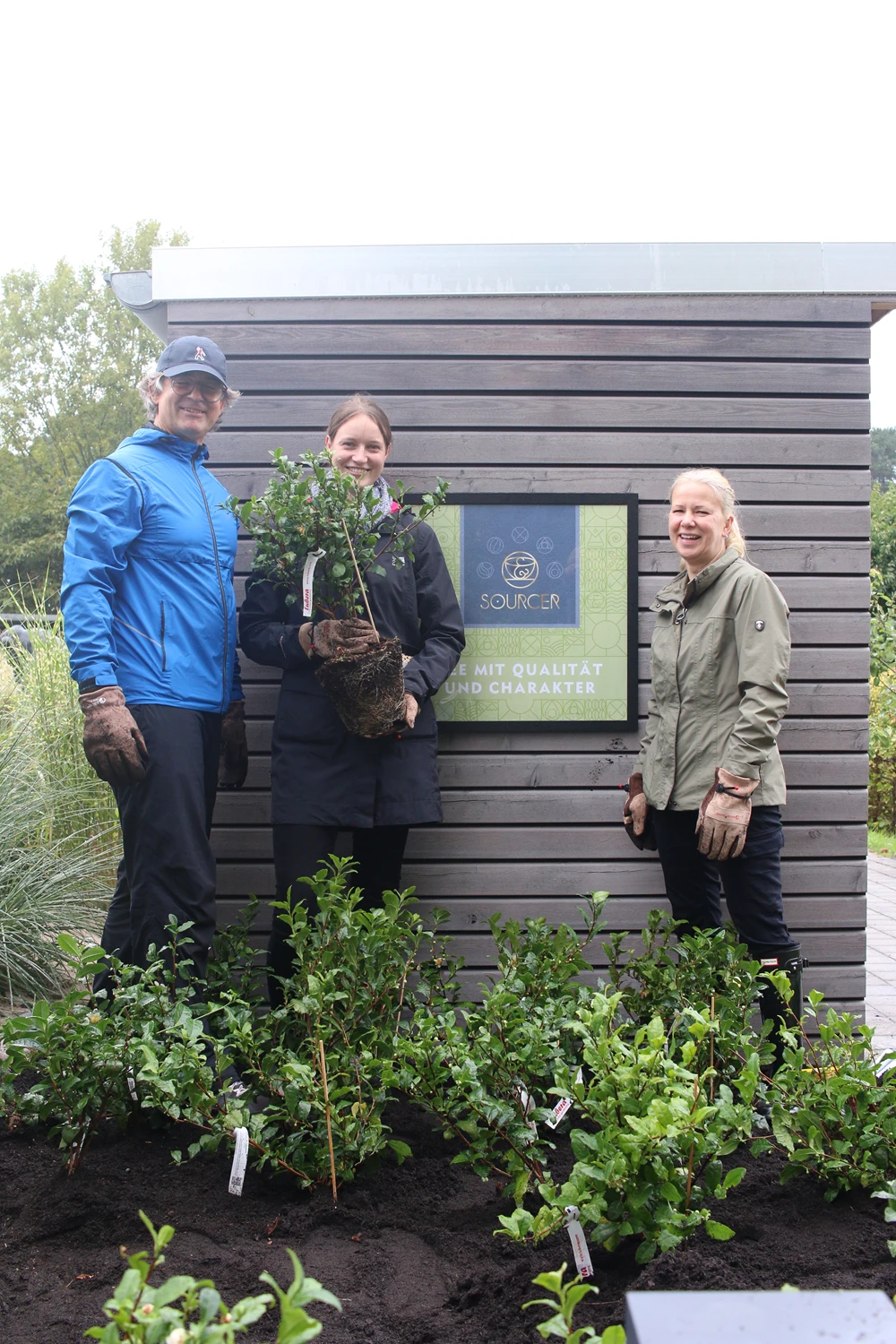 Partner Lifebrands spendete dem Marken-Team um Sourcer in der Service-Bund Zentrale in Lübeck 20 Teepflanzen Eine Gruppe von Menschen posiert für ein Foto im Freien.