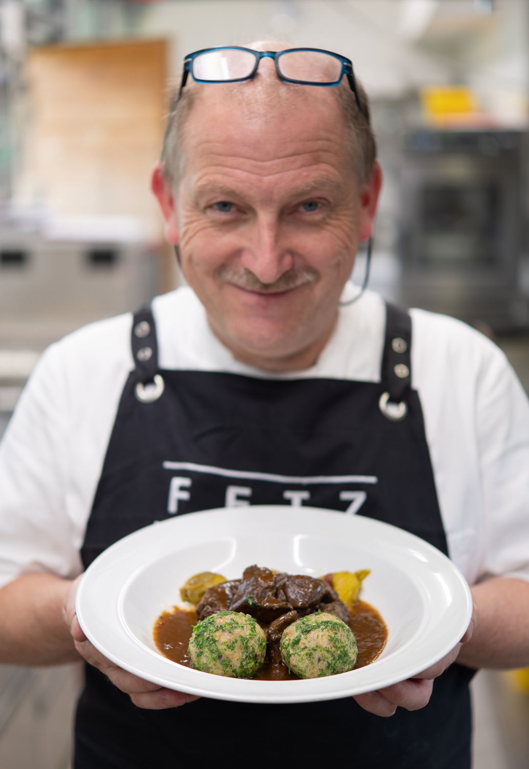 Ludger Fetz vom Hotel Das Freiberg Ein Mann hält einen Teller mit Essen.