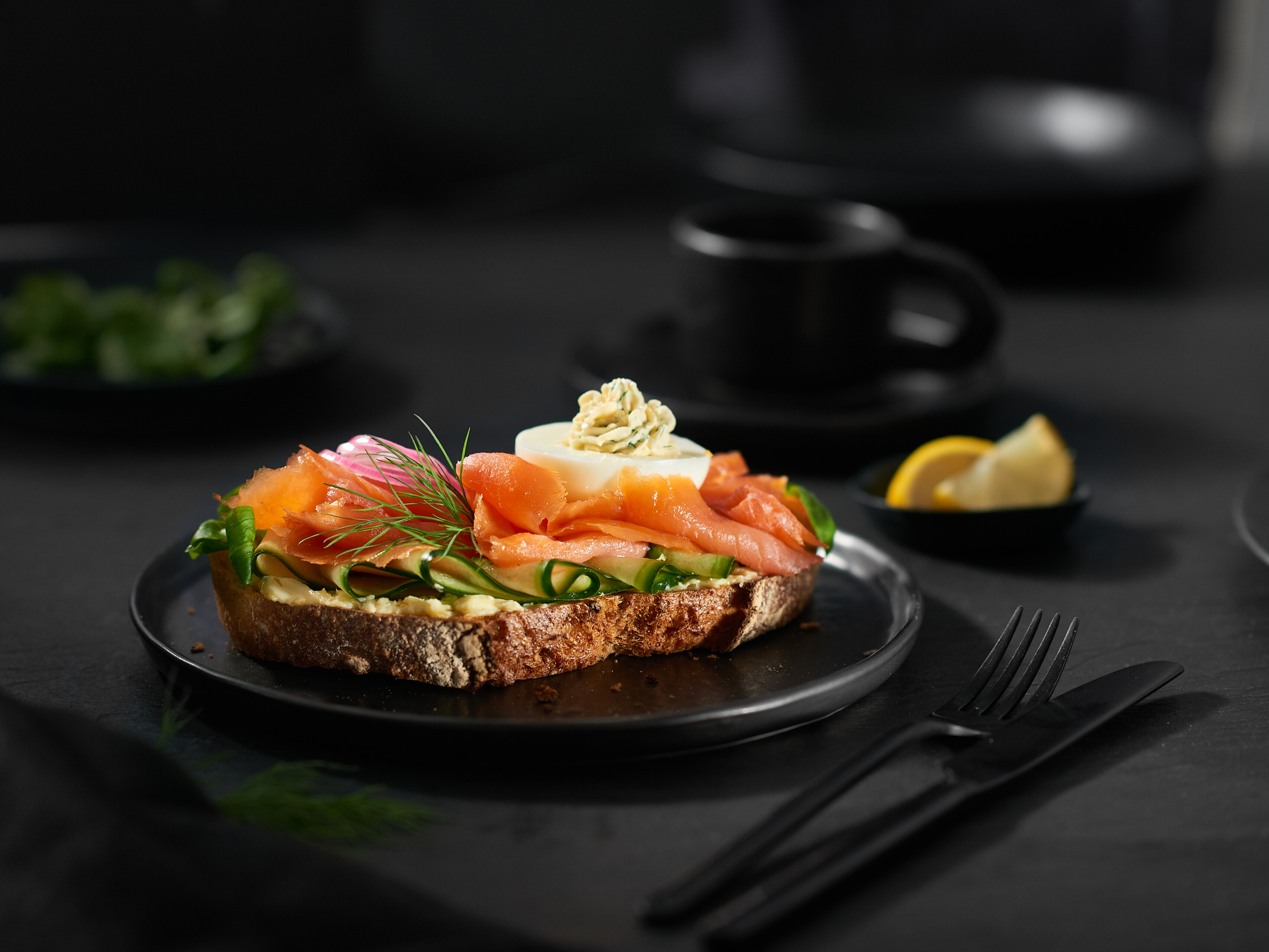 Smörbröd mit Räucherlachs Ein Teller mit einer Scheibe Brot belegt mit Räucherlachs, Salat und Ei